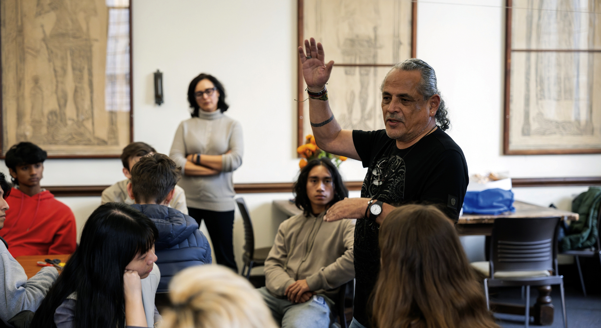 At a meeting of El Cafecito, Pilsen-based artist Ramón Marino explains, in Spanish, how to make traditional Day of the Dead crafts.