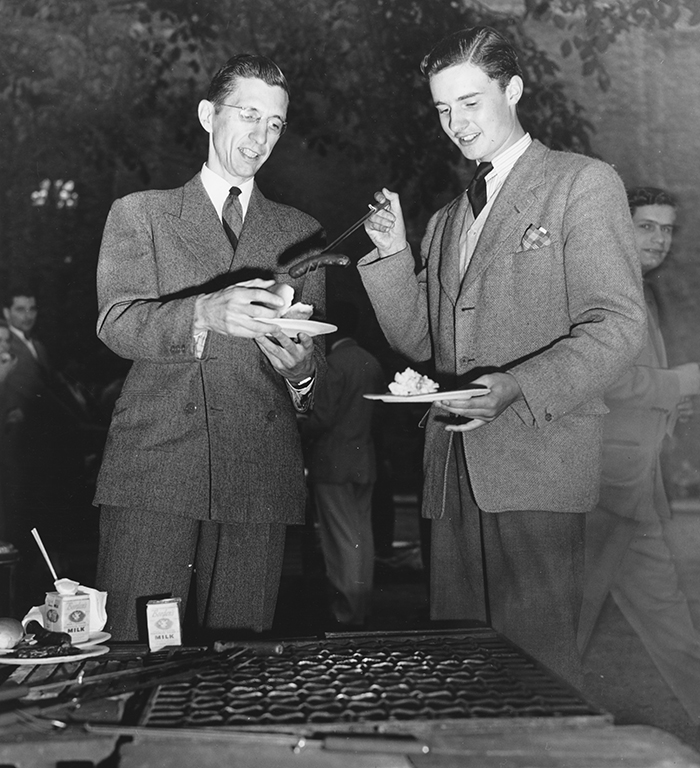 1951 Orientation Week picnic, Anthony St. Clere Berkeley Gage, EX’53, serves a hot dog to F. Champion Ward,