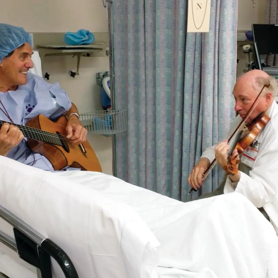 William Sloan and a patient playing a song before surgery