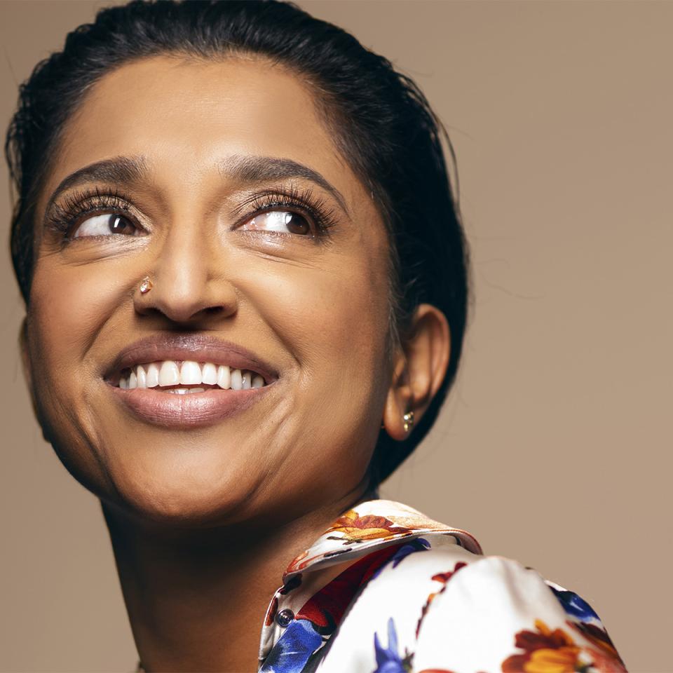 close of Sindhu Vee smiling and looking to the right, wearing a colorful blouse