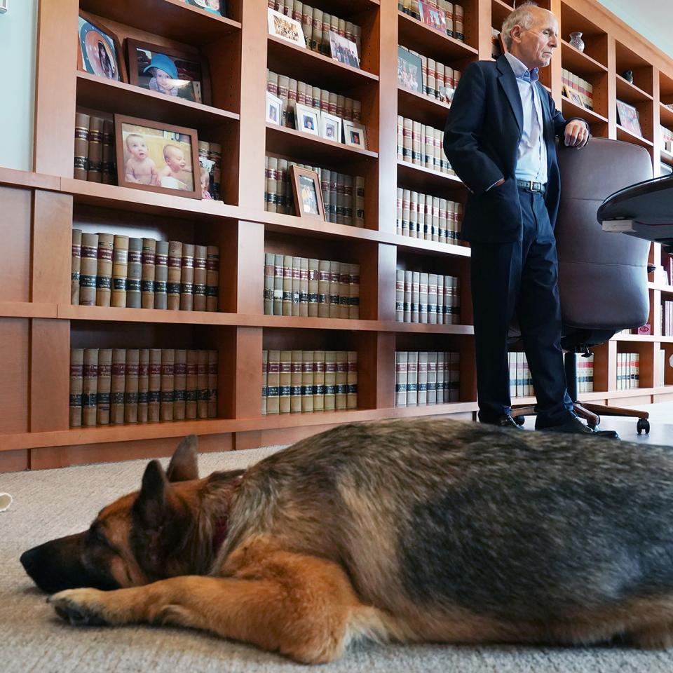 Foreground, German shepherd guide dog Vixen; background Judge David S. Tatel (retired)