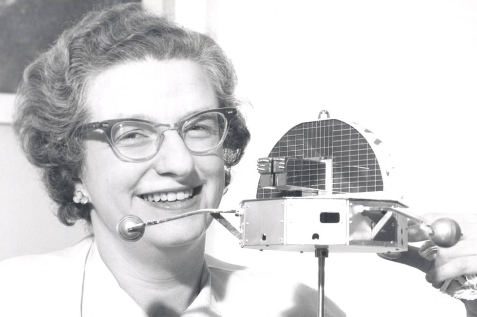Nancy Grace Roman holds a model of the Orbiting Solar Observatory.