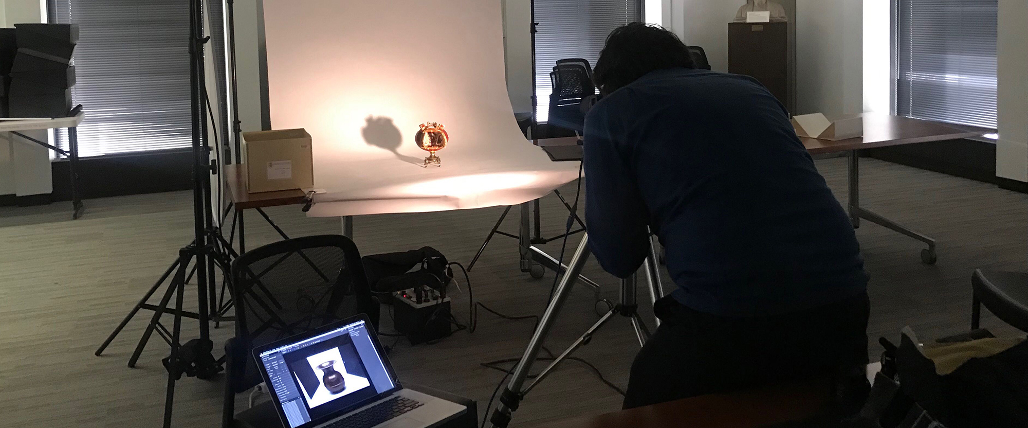 Photographer Nathan Keay photographing a decorated egg from the Special Collections Research Center
