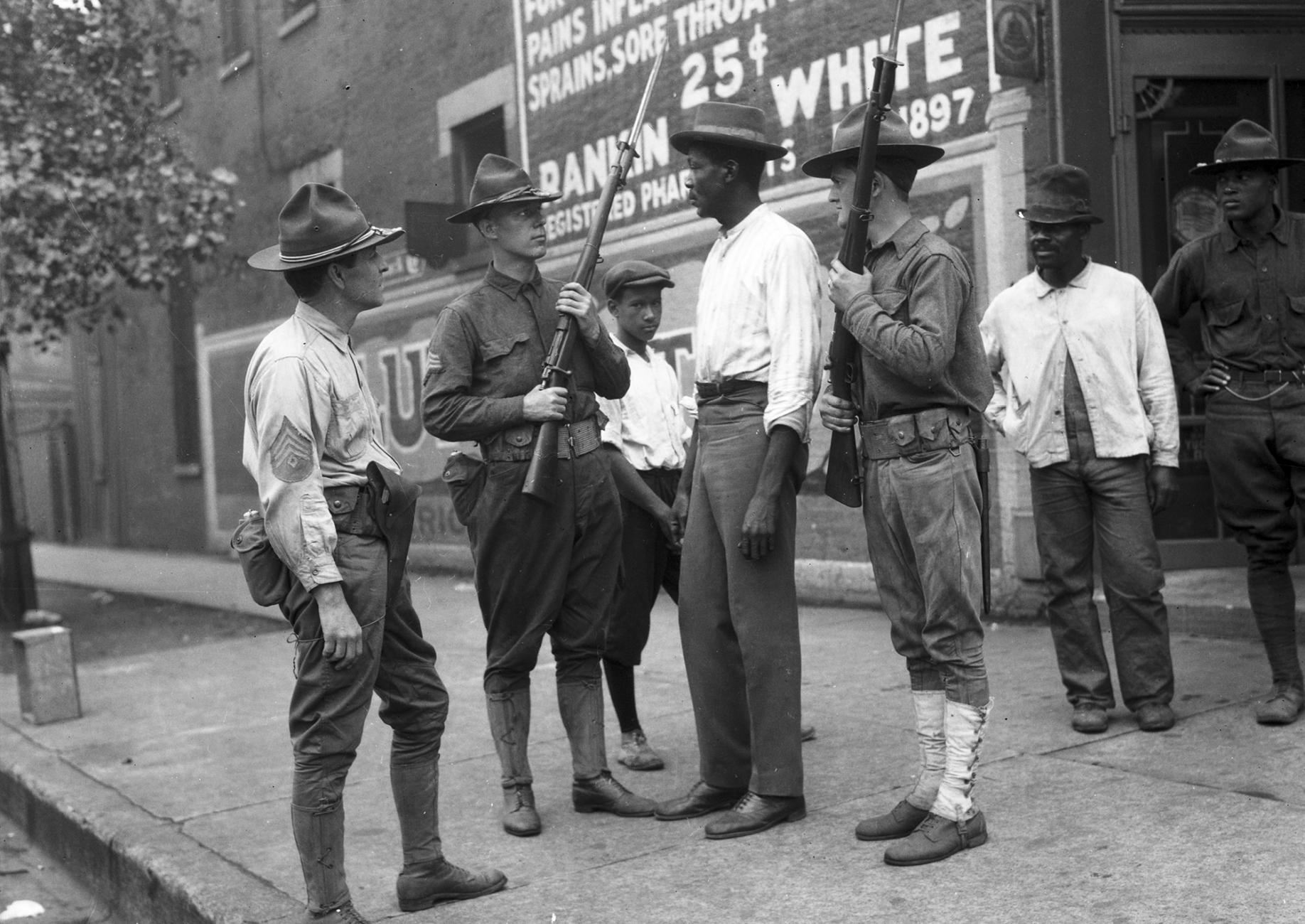 National Guard soldiers and African American men on a street corner in Chicago during the 1919 race riot