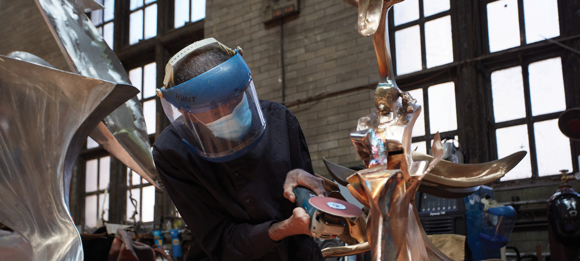 Sculptor Richard Hunt sanding a work in progress