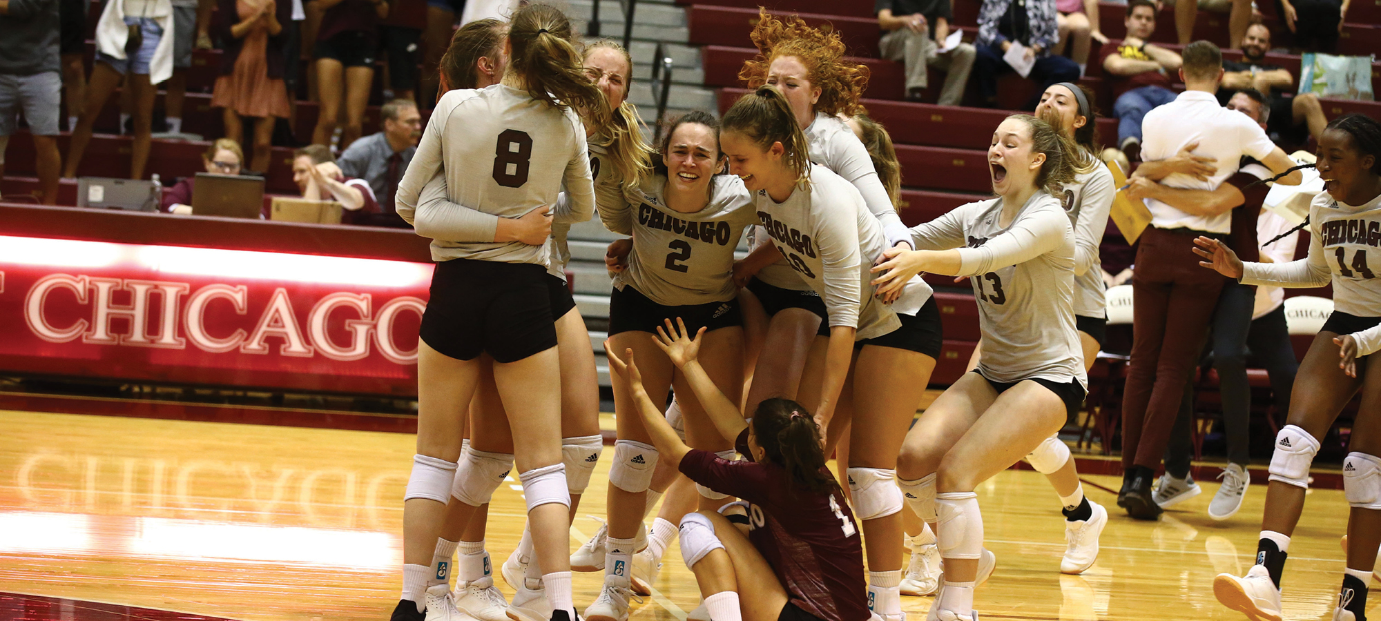 UChicago's women's volleyball team celebrating a win in 2019