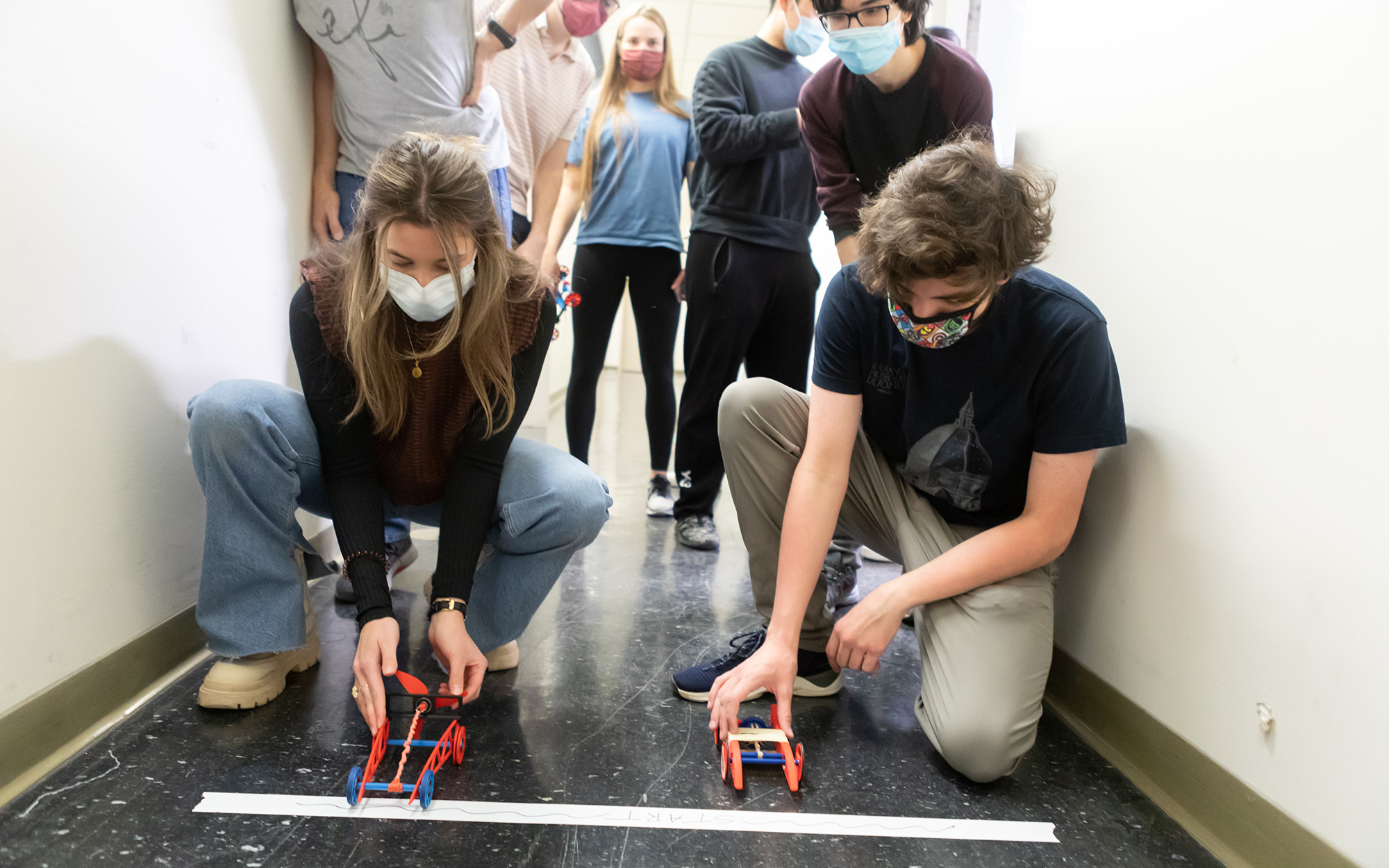 Students racing rubber band–powered cars