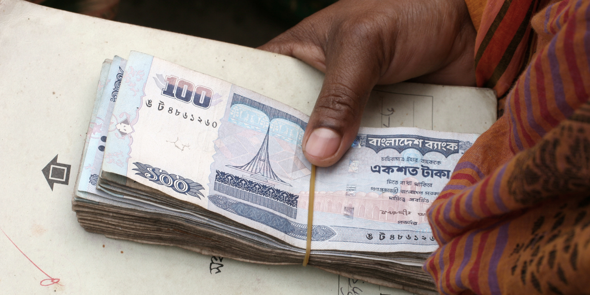 Grameen Bank borrower presents her loan repayment