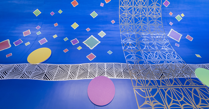 The wall of the Smart Museum lobby decorated with several colorful Robert Earl Paige motifs