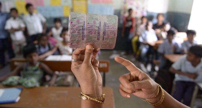 A Hyderabad teacher holding a pack of Albendazole tablets