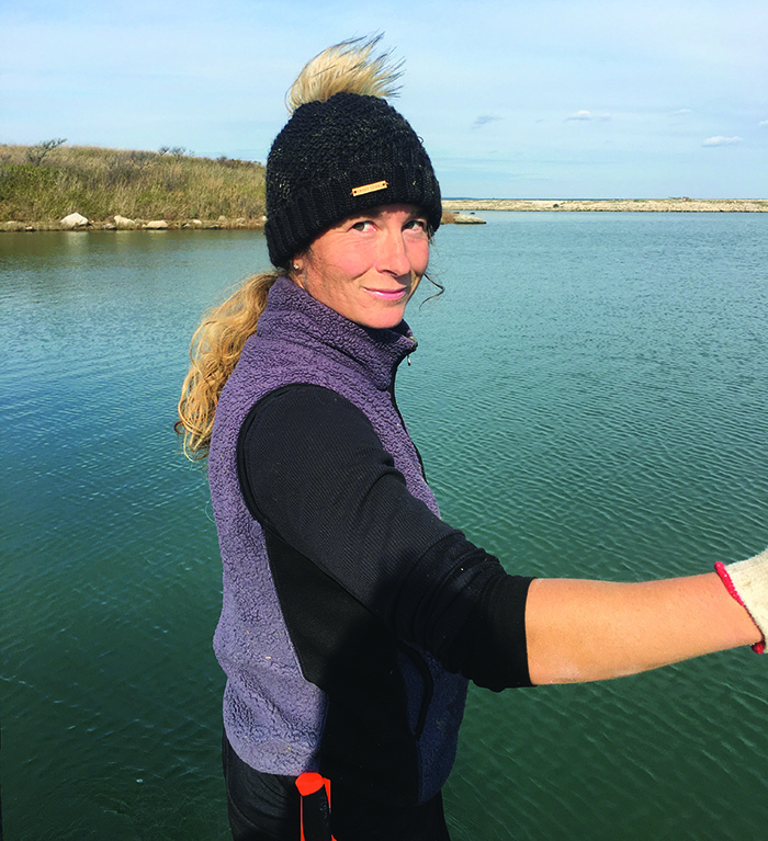 Charmain Gahan on the water wearing a black knit hat a purple fleece vest