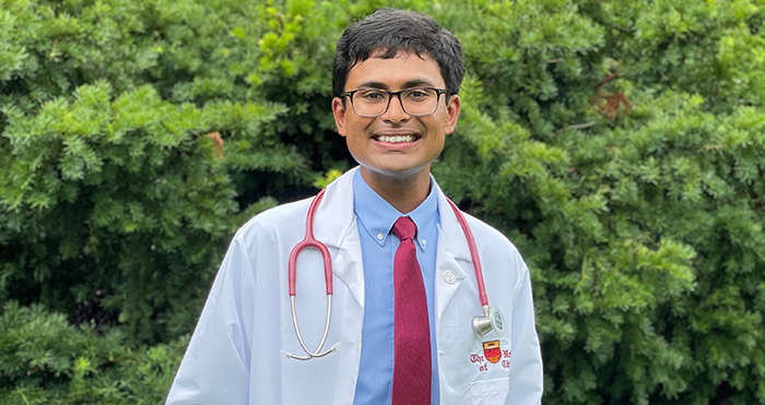 Nitin Vidyasagar standing outside wearing his white lab coat and a stethoscope