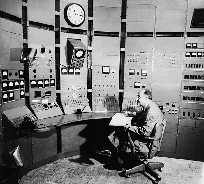 Fermi sits at the controls of the synchrocyclotron