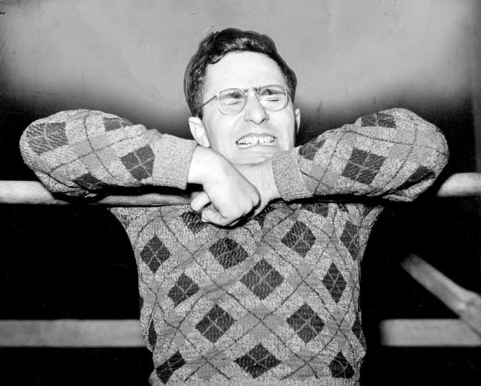 a young man trying to do a chin up wearing an argyle sweater