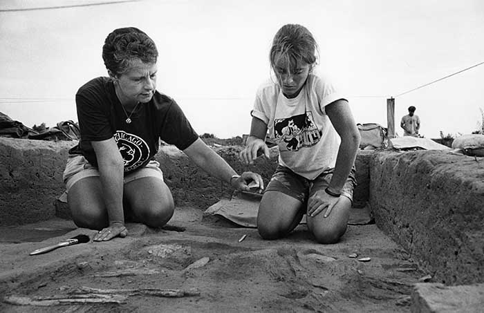 two women working at an archaeological dig site 