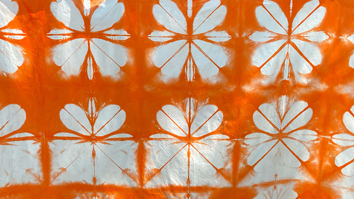 Orange and white fabric with repeated dye pattern