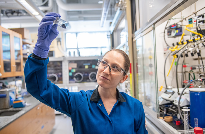 Chemist Amanda Brewer holding a bottle of the Carver blue pigment in the lab