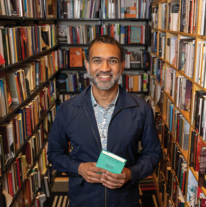 Srikanth “Chicu” Reddy standing in a bookstore holding a book